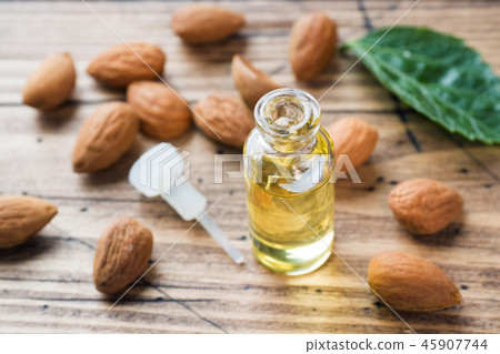 Almond oil in bottle on wooden background. Almond oil in bottle on wooden background. 45907744