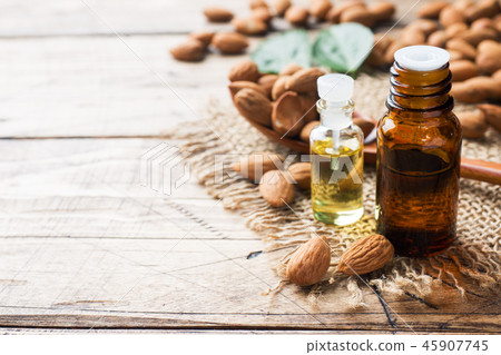 Almond oil in bottle on wooden background. Almond oil in bottle on wooden background. 45907745