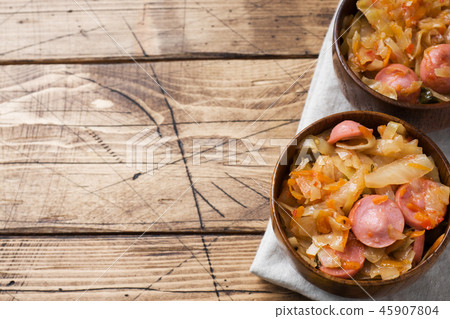 Stewed cabbage with sausages in a plate  45907804