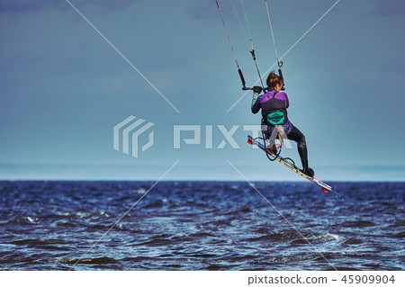 A female kiter slides on the surface of the water A female kiter slides on the surface of the water 45909904