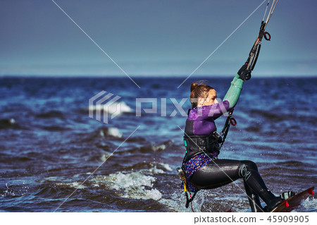 A female kiter slides on the surface of the water A female kiter slides on the surface of the water 45909905