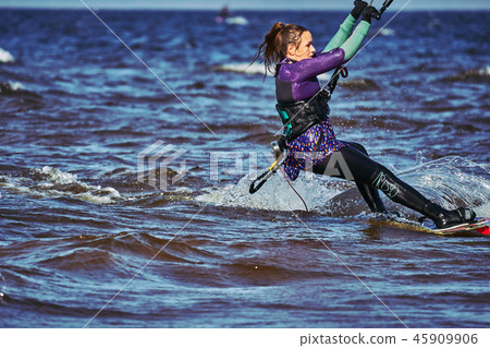 A female kiter slides on the surface of the water 45909906