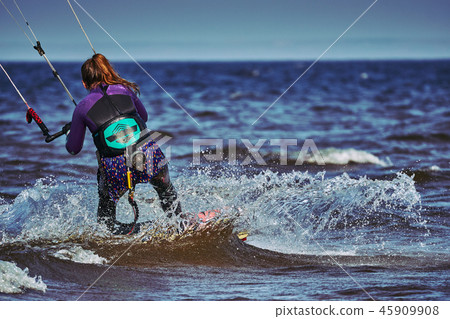 A female kiter slides on the surface of the water A female kiter slides on the surface of the water 45909908