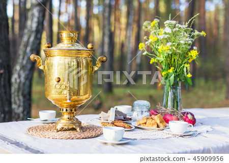 Table with russian samovar, cups decorated with some flowers 45909956