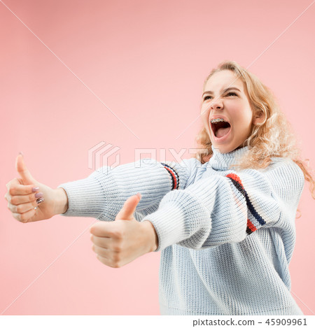 The happy business woman standing and smiling against pink background. 45909961