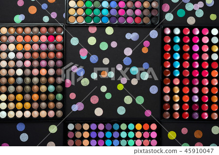 Cosmetic make-up palettes with scattered colorful confetti on black background Cosmetic make-up palettes with scattered colorful confetti on black background 45910047