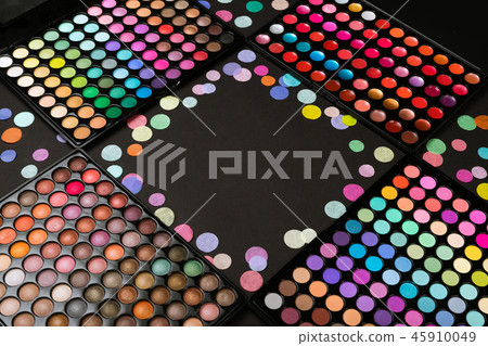 Make-up palettes with scattered colorful confetti on black background with copyspace Make-up palettes with scattered colorful confetti on black background with copyspace 45910049
