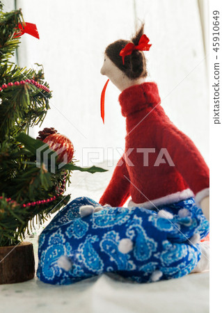 Soft textile doll near a Christmas tree with gifts Soft textile doll near a Christmas tree with gifts 45910649