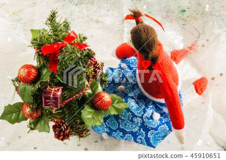 Soft textile doll near a Christmas tree with gifts 45910651