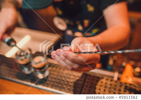Bartender making shots on black bar with reflection. Bartender making shots on black bar with reflection. 45911562