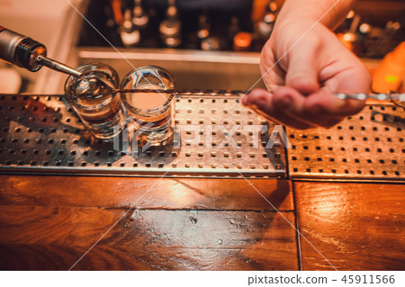 Bartender making shots on black bar with reflection. Bartender making shots on black bar with reflection. 45911566