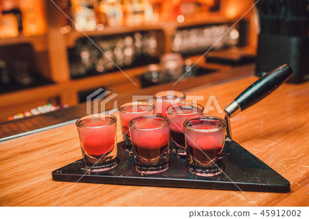 Bartender is pouring tequila into glass against the background of the bar. 45912002