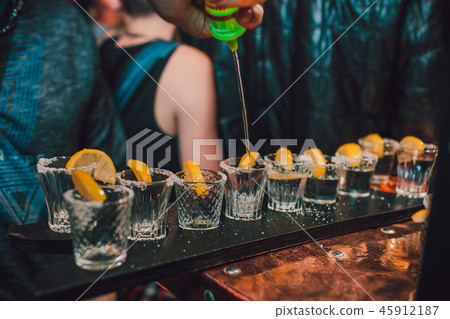 Tequila shot with lime and sea salt on black table, selective focus 45912187