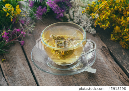 Glass tea cup with tea bag of healthy herbal tea. Glass tea cup with tea bag of healthy herbal tea. 45918298