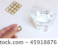 Hand holding a pill and water 45918876