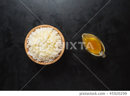 White basmati rice and ghee oil on the black table White basmati rice and ghee oil on the black table 45920299