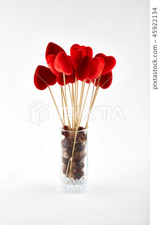 Red hearts on wooden sticks and chestnuts in glass 45922134