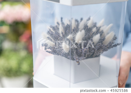 Woman holding bunch of lavender and cotton. Bouquet of dry flowers in a gift box with glass. The 45925586