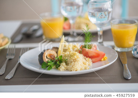bulgur with vegetables and rolls of baked fish 45927559