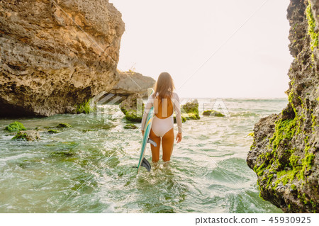 Surfer woman with surfboard in ocean 45930925