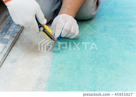 A worker is cutting a fiberglass mesh. A worker is cutting a fiberglass mesh. 45931027
