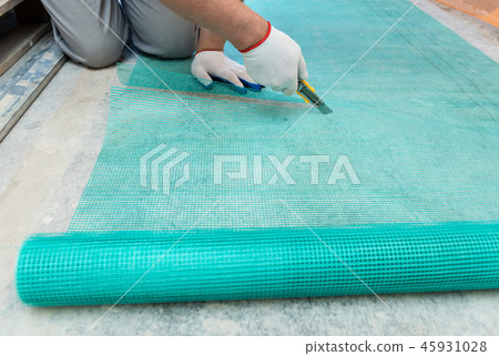A worker is cutting a fiberglass mesh. A worker is cutting a fiberglass mesh. 45931028