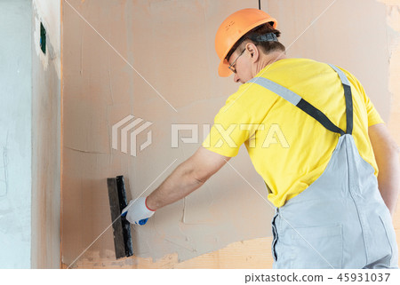 The construction worker putty a wall. The construction worker putty a wall. 45931037