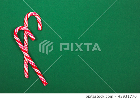 Christmas candy canes on green background. 45931776