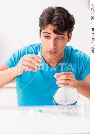 Man trying contact lenses at home 45932290