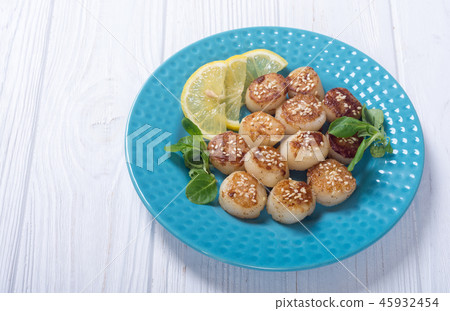 Fried scallops with lemon and salad Fried scallops with lemon and salad 45932454