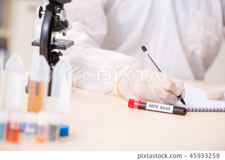 Young handsome lab assistant testing blood samples in hospital  45933259