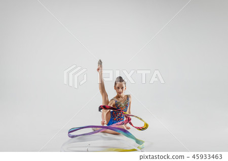 The portrait of beautiful young brunette woman gymnast training calilisthenics exercise with ribbon 45933463