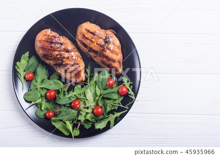 Grilled chicken with spinath and tomatoes salad 45935966