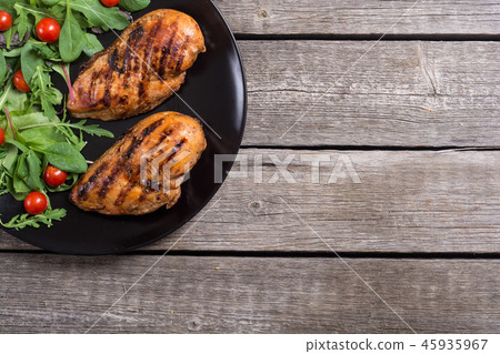 Grilled chicken with spinath and tomatoes salad 45935967