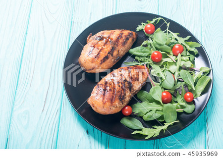 Grilled chicken with spinath and tomatoes salad Grilled chicken with spinath and tomatoes salad 45935969