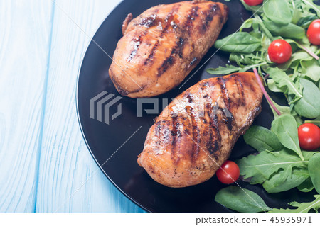Grilled chicken with spinath and tomatoes salad Grilled chicken with spinath and tomatoes salad 45935971