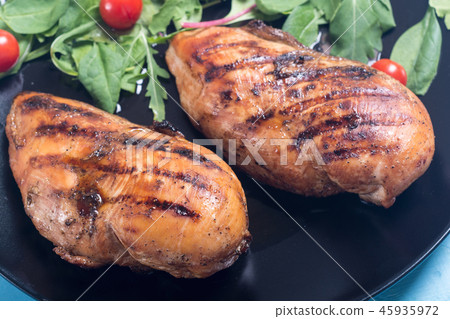 Grilled chicken with spinath and tomatoes salad 45935972