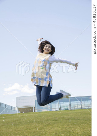 Nursery teacher jumping in the blue sky Nursery teacher jumping in the blue sky 45936117