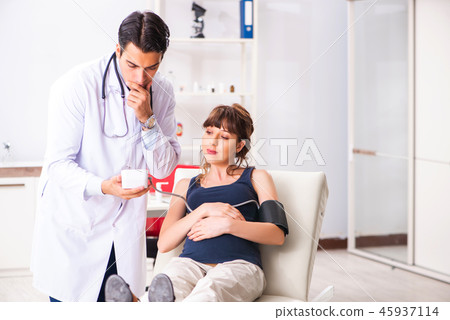 Young doctor checking pregnant woman's blood pressure 45937114