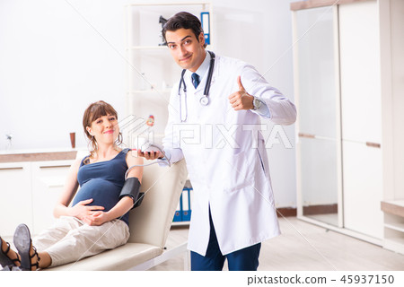 Young doctor checking pregnant woman's blood pressure 45937150