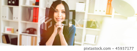 A young girl is sitting in the office at the table. 45937177