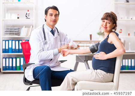 Young doctor checking pregnant woman's blood pressure 45937197