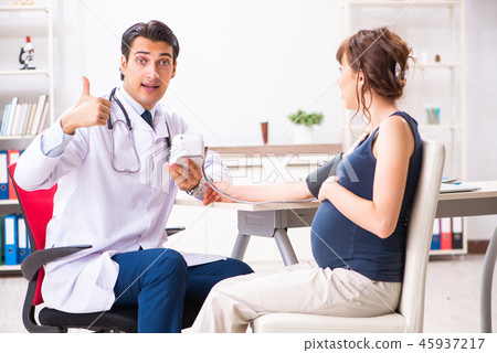 Young doctor checking pregnant woman's blood pressure 45937217