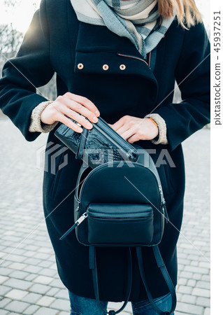 Young woman put wallet in backpack 45937251