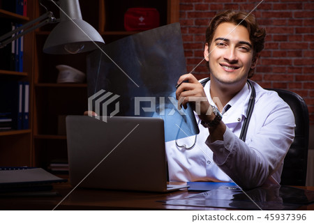 Young handsome doctor working night time at the hospital Young handsome doctor working night time at the hospital 45937396