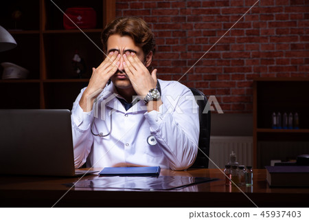 Young handsome doctor working night time at the hospital  45937403