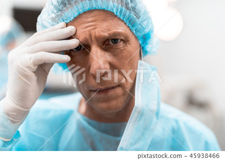 Unhappy doctor looking and touching his forehead 45938466