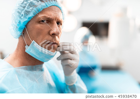 Worried doctor turning his head and looking Worried doctor turning his head and looking 45938470