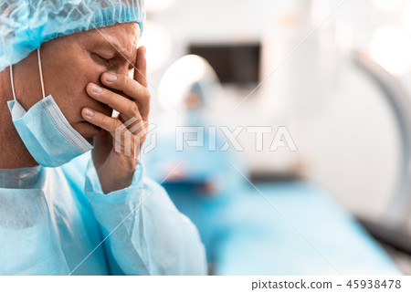 Exhausted doctor closing his eyes after having difficult day Exhausted doctor closing his eyes after having difficult day 45938478
