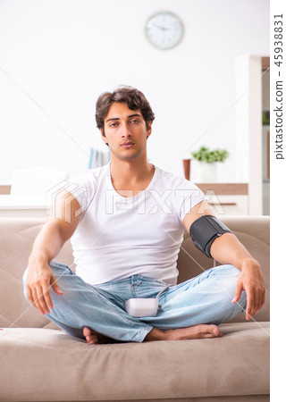 Young man measuring blood pressure at home 45938831